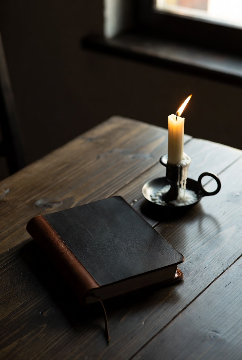 Leather journal and candle on wood table — the evening accounting